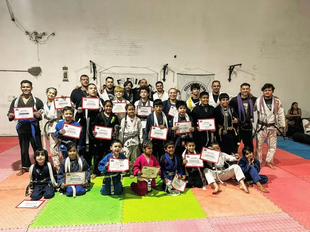 Graduación en Warriors Combat Team: chicos y adultos con sus certificados sobre el tatami